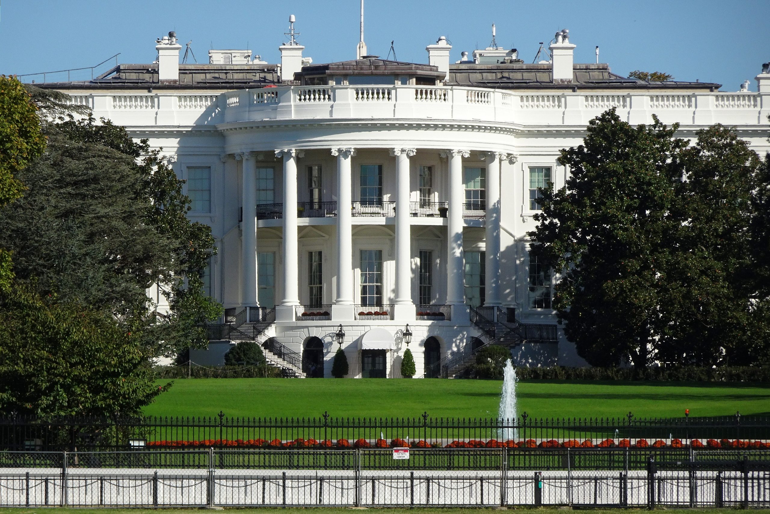 Front view of the iconic White House in Washington, DC, showing its lawn and fountain under the Trump Administration